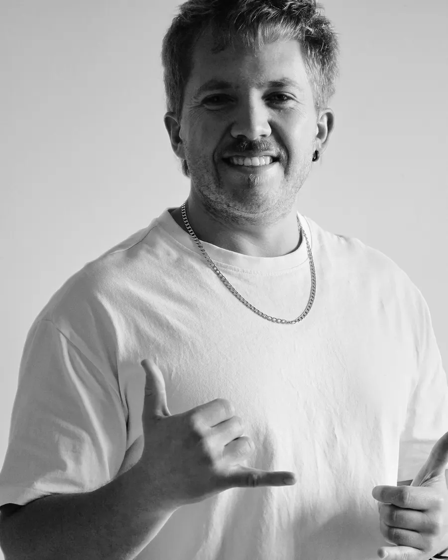Quewin Human smiling and making a shaka sign, black and white